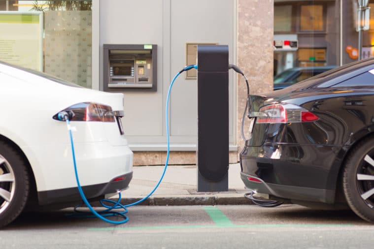 Electric cars plugged in to charging station